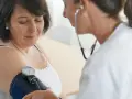 Lekarka bada ciśnienie pacjentce za pomocą ciśnieniomierza. To ważny element profilaktyki, kontrola ciśnienia jest kluczowa.
