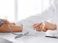 Lekarz mierzy ciśnienie krwi pacjentowi za pomocą ciśnieniomierza.