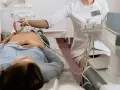 Lekarka wykonuje badanie USG transwaginalne pacjentce leżącej na kozetce.