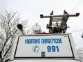 Tył białego samochodu pogotowia energetycznego z napisem "POGOTOWIE ENERGETYCZNE 991" i drabiną na dachu.