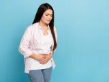Kobieta z zamkniętymi oczami trzyma się za brzuch, cierpiąc z powodu bólu sugerującego gastroparezę.