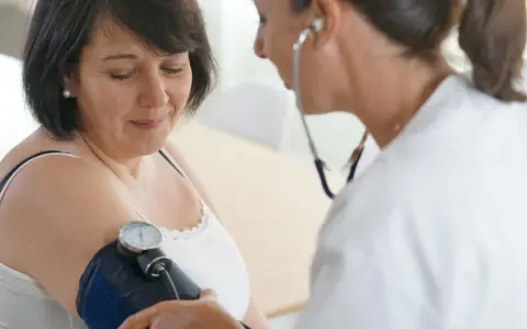 Lekarka bada ciśnienie pacjentce za pomocą ciśnieniomierza. To ważny element profilaktyki, kontrola ciśnienia jest kluczowa.