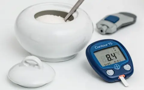 Glukometr pokazuje 8.4 mmol/L. Czy to norma dla hemoglobiny glikowanej? Obok cukiernica i nakłuwacz.