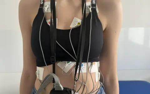 Osoba z elektrodami EKG przyczepionymi do klatki piersiowej i brzucha.
