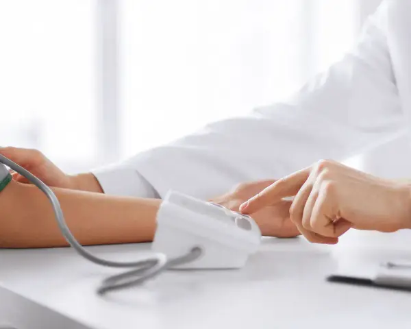 Lekarz mierzy ciśnienie krwi pacjentowi za pomocą ciśnieniomierza.
