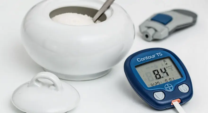 Glukometr pokazuje 8.4 mmol/L. Czy to norma dla hemoglobiny glikowanej? Obok cukiernica i nakłuwacz.