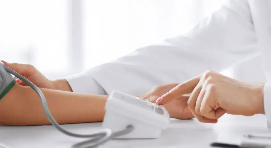 Lekarz mierzy ciśnienie krwi pacjentowi za pomocą ciśnieniomierza.