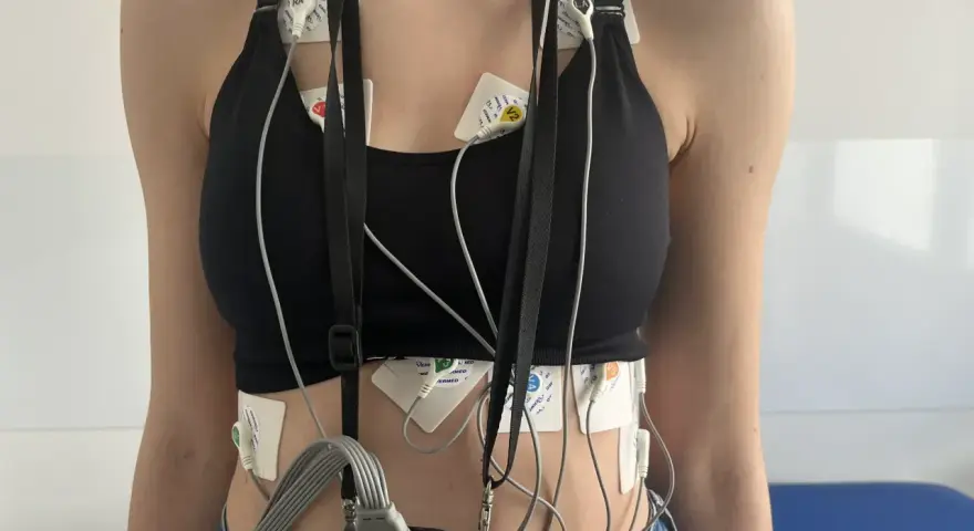 Osoba z elektrodami EKG przyczepionymi do klatki piersiowej i brzucha.